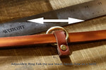 Tan leather belt with adjustable ring fob on a wooden surface with ruler.