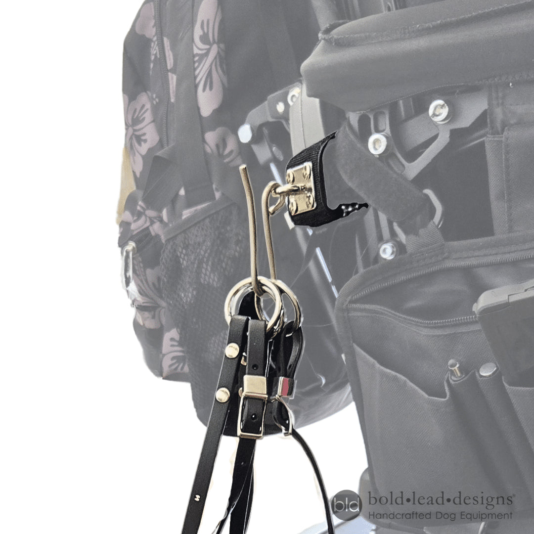 leash hook holding 3 rings of the JJ Special quad lead attached to a power wheelchair, the wheelchair is greyed out with focus on the hook and leash