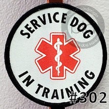 Service dog in training patch with red star of life symbol on a white background
