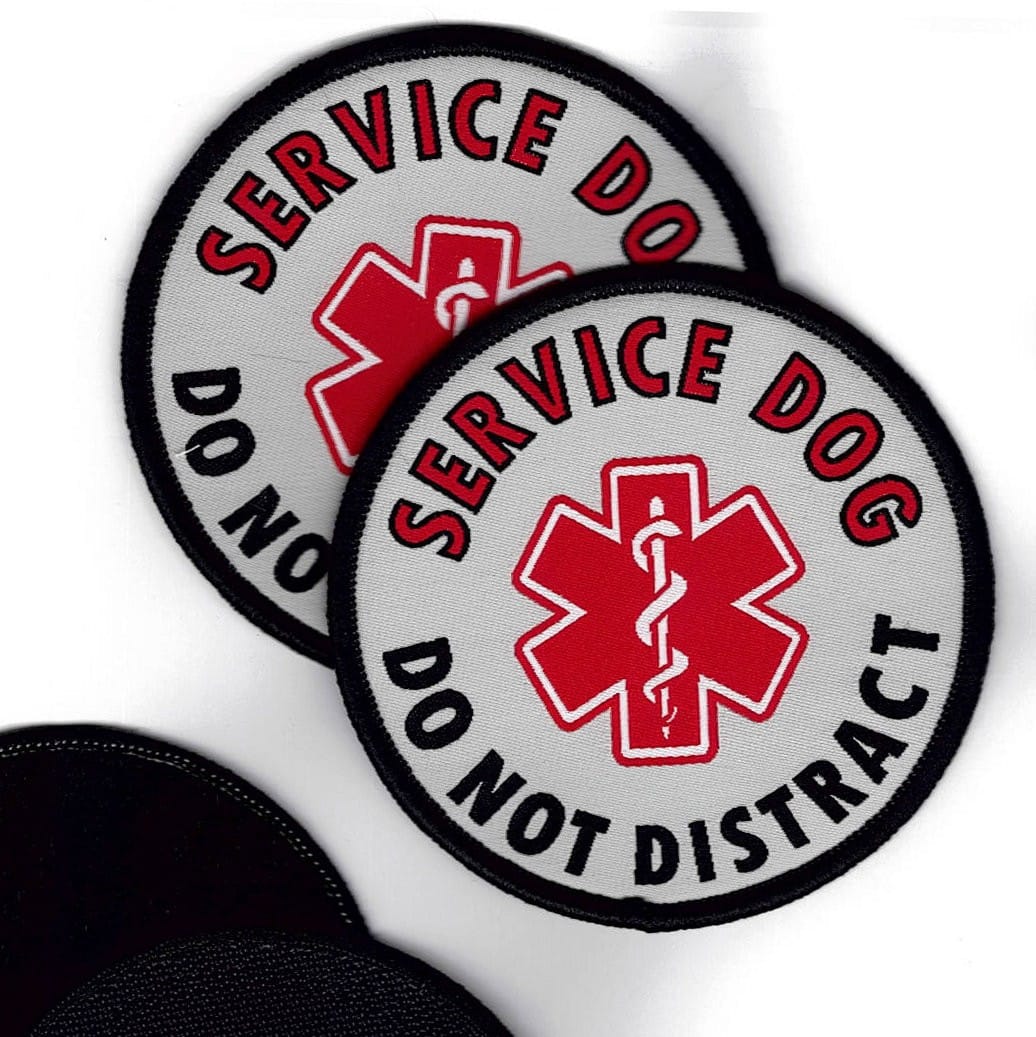 Two 'Service Dog Do Not Distract' patches with a red medical symbol, with hook and loop Velcro on a white background.