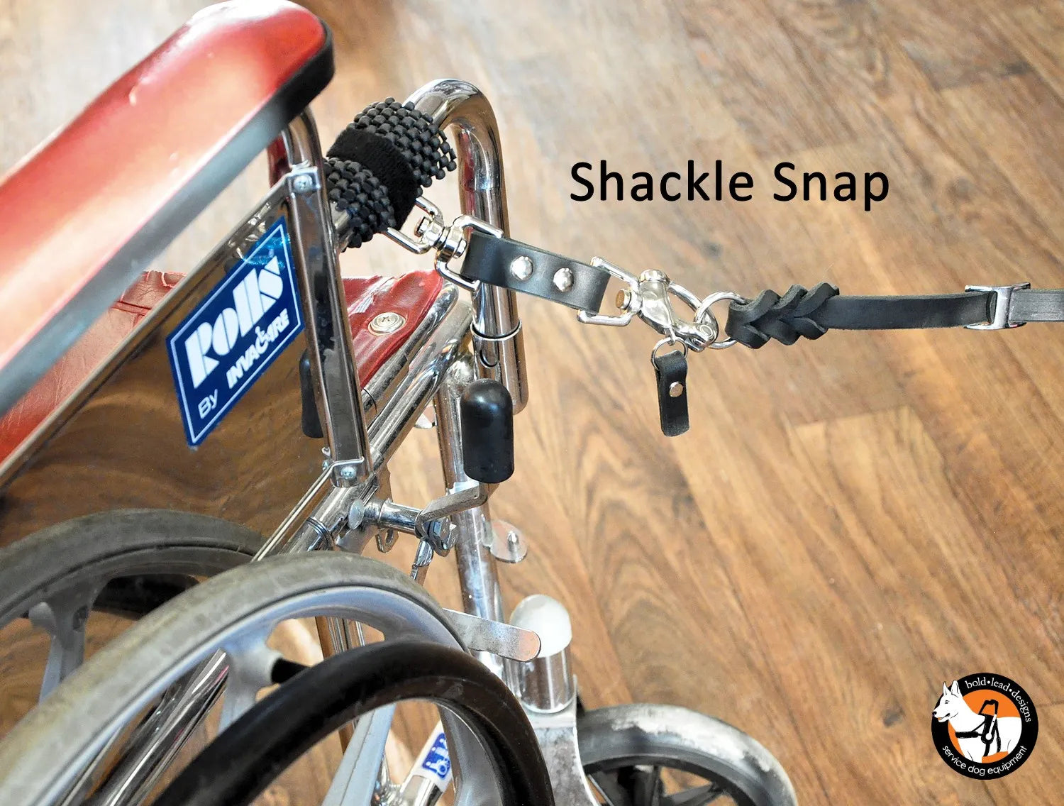 Shackle snap attached to a manual chair with a wooden floor background