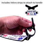 Hand holding a banner badge with Velcro strips and text "includes Velcro strips to attach to handle"