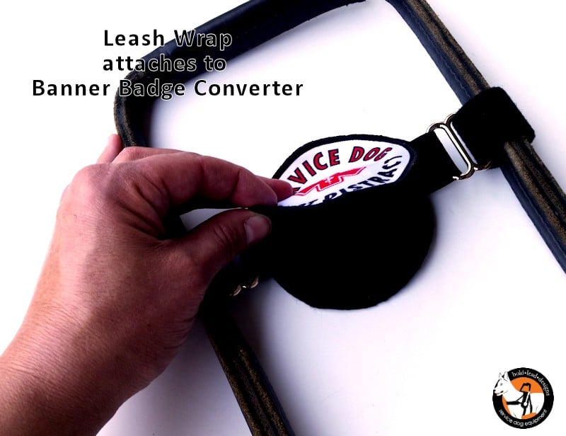Hand attaching a leash wrap to a banner badge converter with text on a white background.