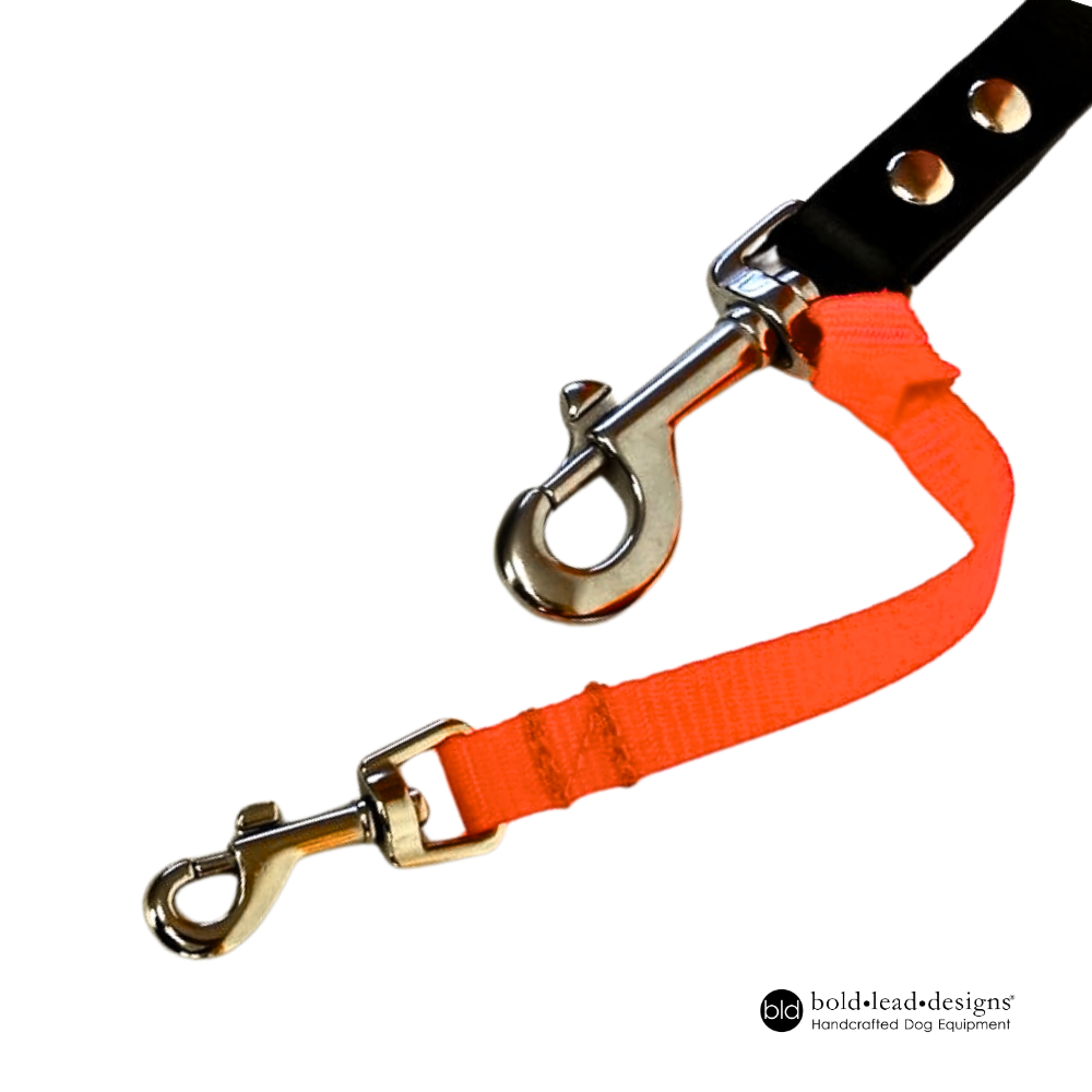 florescent flat nylon safety cord shown attached to the snap on a wide black leash on a white background