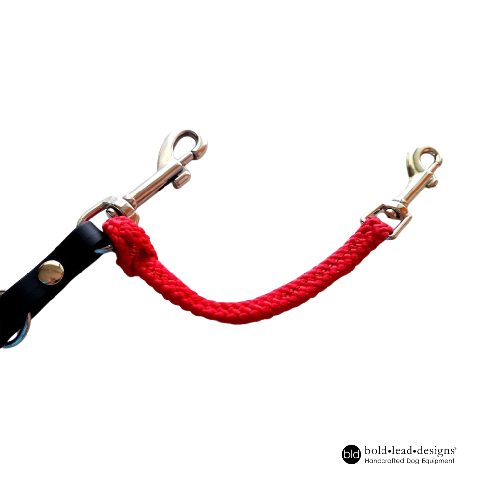 Red woven safety cord connector strap attached to a silver snap hook on a black leash a white background, featuring 'bold lead designs' branding.