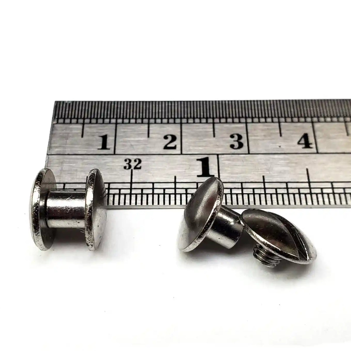3/16 inch Chicago screw "shorties" with a ruler for scale on a white background