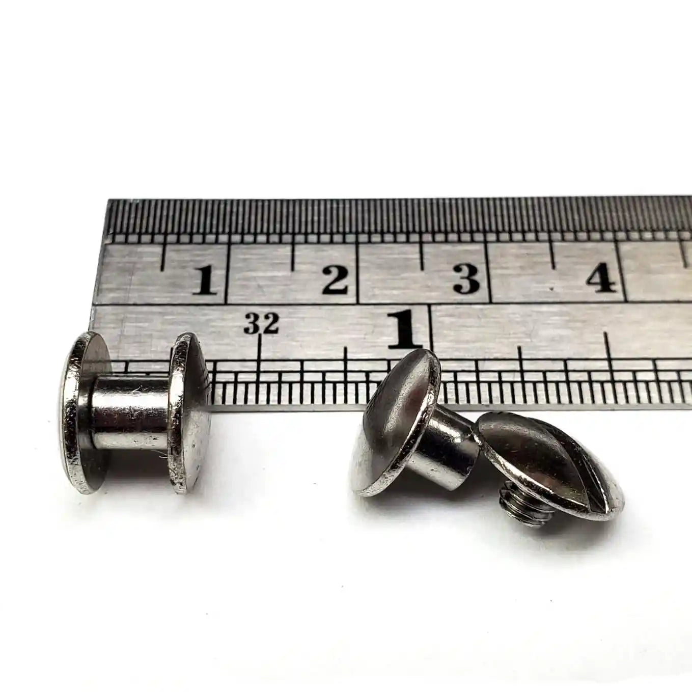 3/16 inch Chicago screw "shorties" with a ruler for scale on a white background